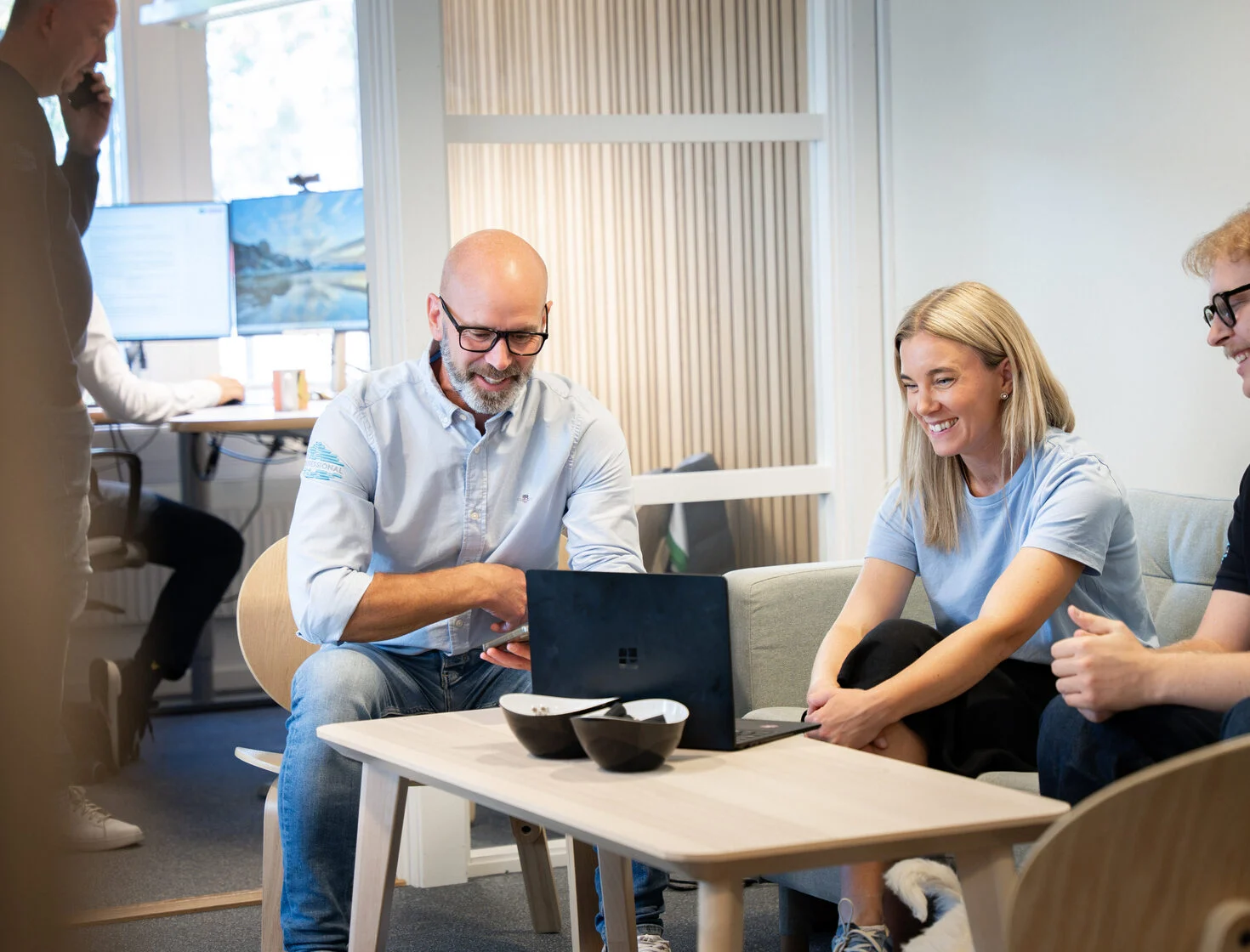Medarbetare samtalar runt ett bord på kontoret