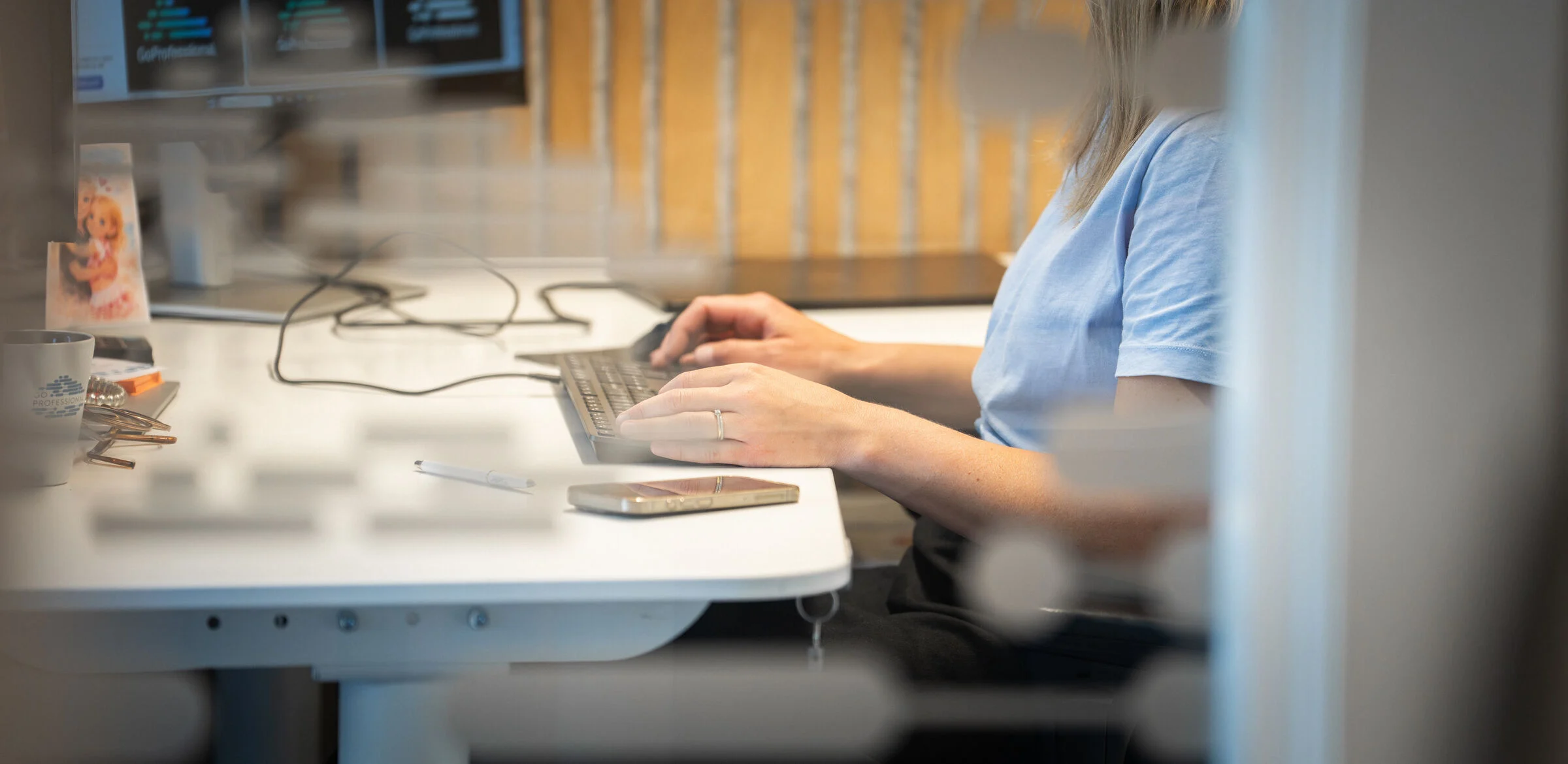 Medarbetare skriver på ett tangentbord vid sitt skrivbord